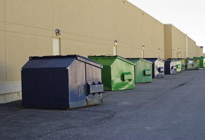 a pile of demolition waste sits beside a dumpster in a parking lot in Baldwin Park, CA